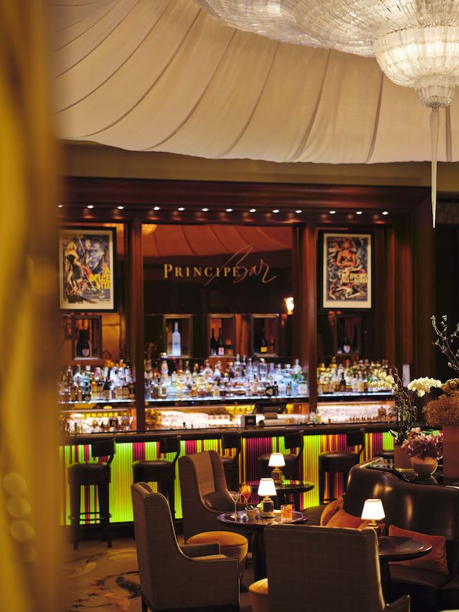 Principe bar, ambiente serale, con tavoli apparecchiati per l'aperitivo e la bottigliera sullo sfondo